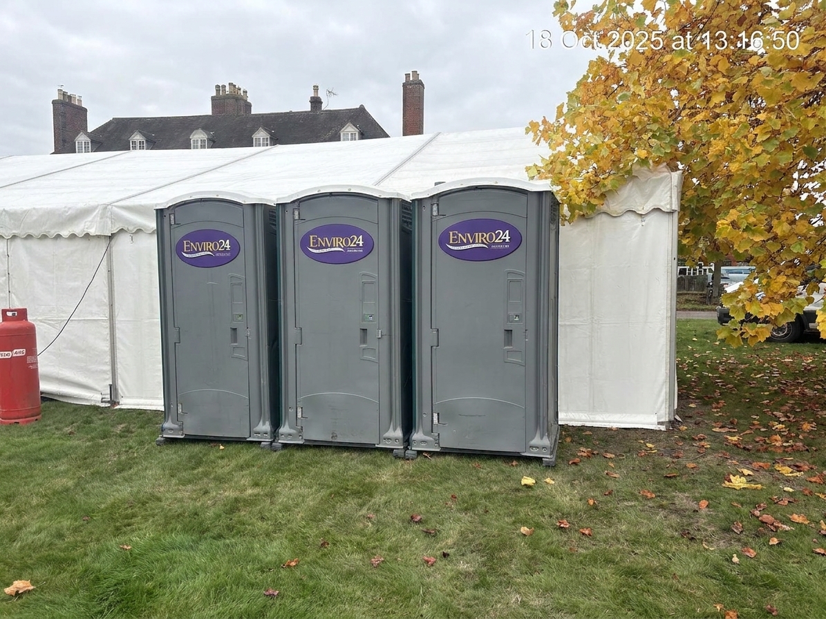 Enviro24 portable toilets lined up beside a marquee at a Leicester event